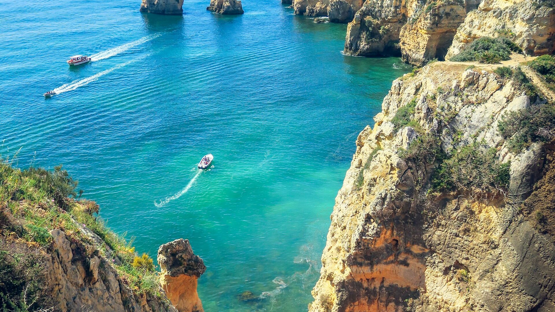 Formations rocheuses dorées au bord de la mer bleue, côte de l'Algarve au Portugal