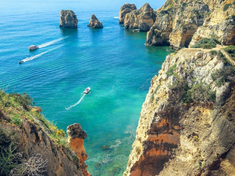 Formations rocheuses dorées au bord de la mer bleue, côte de l'Algarve au Portugal